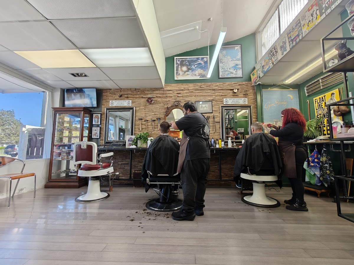 Barbers cutting hair at both chairs inside Old Dogs Barbershop
